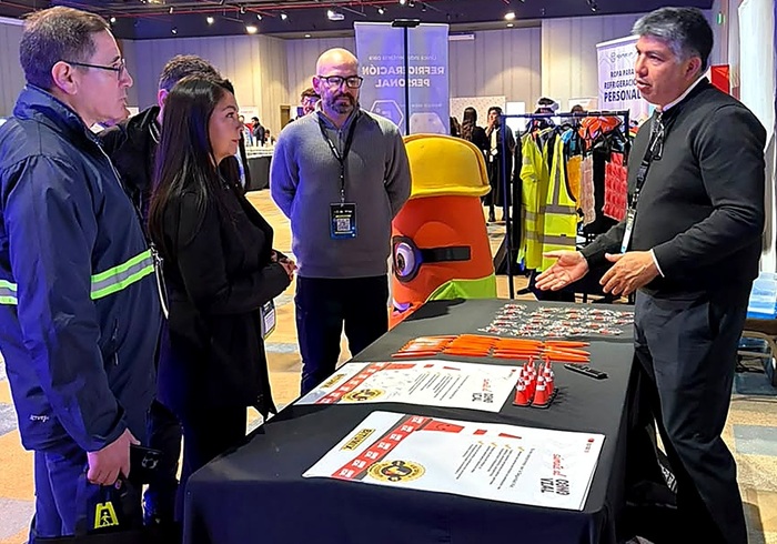 Visitantes recorren el stand de Bitumix en Traffic Chile 2026 mientras representantes de la empresa explican iniciativas de seguridad vial y prevención de riesgos junto a material informativo y elementos corporativos de la marca.