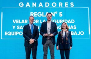 Tres personas durante la entrega del reconocimiento a Bitumix por el primer lugar en el concurso de Buenas Prácticas de la Semana de la Seguridad.